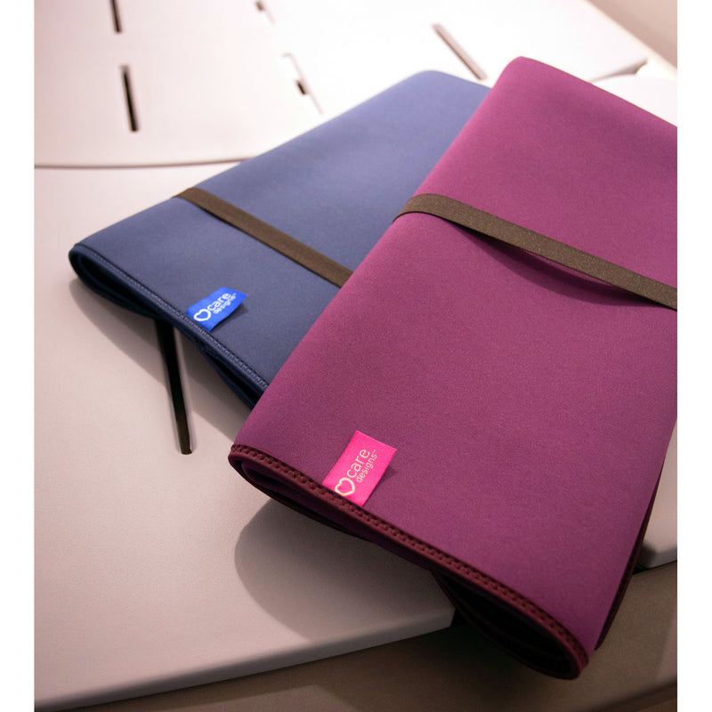 Two rolled-up changing mats, one blue and one purple, on a light surface.