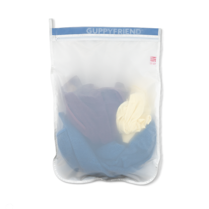 Guppyfriend product in a clear bag with blue and white items inside on a white background