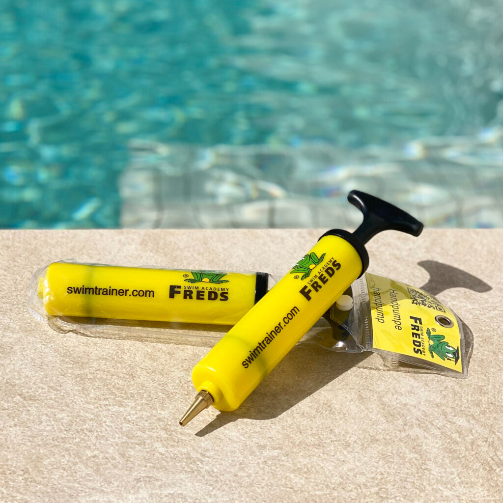 Yellow FREDS hand pump in pool water for inflating Swimtrainer belts and small pool toys